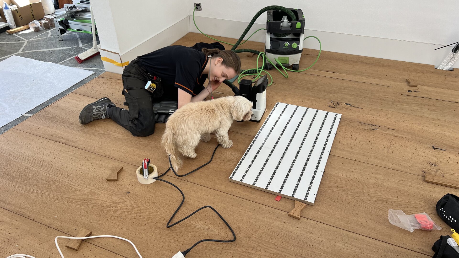 Eine Frau und ein Hund liegen auf dem Boden.